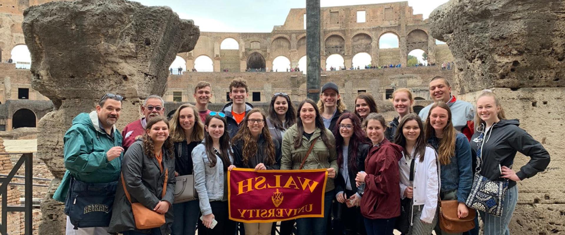 Walsh University Global Learning group in Rome holding up a Walsh flag